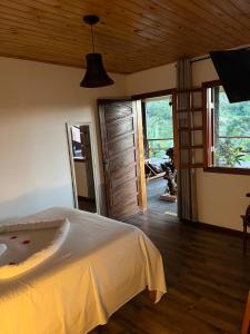 a bedroom with a bed and a wooden ceiling at Hospedaria Sol & Lua in São Bento do Sapucaí