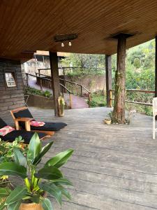 a wooden deck with a table and chairs on it at Hospedaria Sol & Lua in São Bento do Sapucaí +20 photos