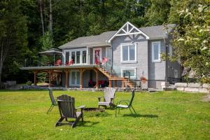 a house with three lawn chairs in the yard at Nature, hot tub and relaxation at its best! in Val des Monts