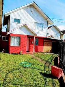 ein Haus mit einem roten und weißen Haus in der Unterkunft Casa Grande roja para 7 personas in San Pedro de la Paz
