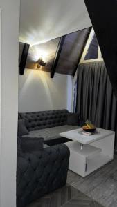 a living room with a couch and a table at Oaza mira, Brutusi near Bjelašnica in Trnovo