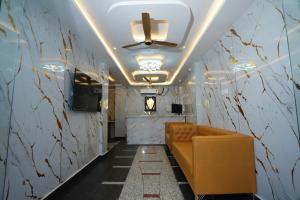 a corridor with a couch in a room with a ceiling at Hotel CK Grand in Jāmb