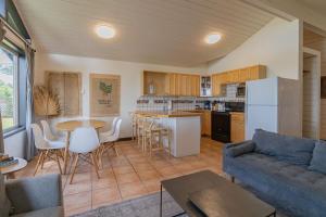 a living room with a couch and a kitchen at Mackenzie Beach Resort in Tofino