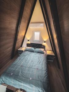 a small bedroom with a bed in a wooden wall at Oaza mira, Brutusi near Bjelašnica in Trnovo