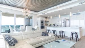 a living room with a white couch and a kitchen at Encantame Towers Velero 901 in Playa Encanto