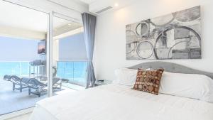 a bedroom with a bed and a view of the ocean at Encantame Towers Velero 901 in Playa Encanto +31 photos