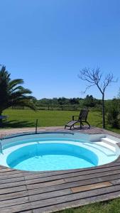- une petite piscine sur une terrasse en bois avec un banc dans l'établissement FincaMora, à Colonia del Sacramento