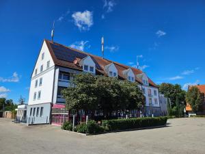 a large white building with a brown roof at Hotel Krone & Restaurant in Königsbrunn