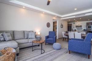 a living room with a couch and blue chairs at Cozy beach front getaway Encantame Towers E304 in Playa Encanto