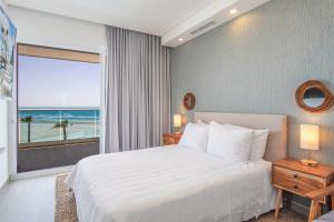 a bedroom with a bed and a view of the beach at Cozy beach front getaway Encantame Towers E304 in Playa Encanto