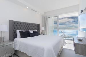 ein Schlafzimmer mit Bett, Schreibtisch und Fenster in der Unterkunft Amazing 2 bedroom Beach Front Condominium at Encantame C1102 in Playa Encanto + 27 Fotos