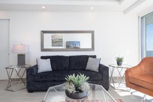 ein Wohnzimmer mit einer schwarzen Couch und einem Sessel in der Unterkunft Amazing 2 bedroom Beach Front Condominium at Encantame C1102 in Playa Encanto