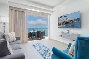 ein Wohnzimmer mit Blick auf das Meer in der Unterkunft Splash in The New Lazy River and Sleep In Luxury Encantame Velero 1103 in Playa Encanto