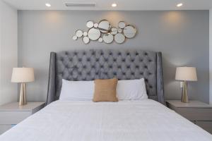 ein großes Bett mit grauem Kopfteil und zwei Lampen in der Unterkunft Splash in The New Lazy River and Sleep In Luxury Encantame Velero 1103 in Playa Encanto + 25 Fotos