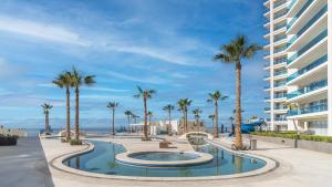 ein Swimmingpool mit Palmen und einem Gebäude in der Unterkunft New and Amazing 3 bedroom Ground Floor Corner Beach Front Encantame C-101 in Playa Encanto