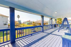 a porch with a blue railing and a ladder on it at Escape Gulf Views Large Deck Pet Friendly in Crystal Beach