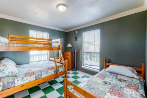 two bunk beds in a room with green walls at Escape Gulf Views Large Deck Pet Friendly in Crystal Beach