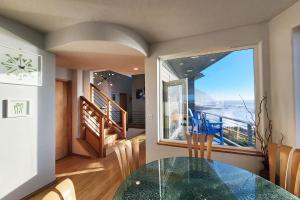 a dining room with a glass table and a large window at Spectacular Ocean Views! Whaley Nice in Yachats