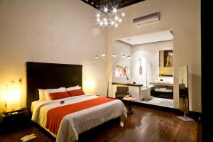 una camera con un grande letto e un grande specchio di Cantera 10 Hotel Boutique a Morelia