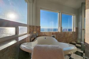 a bath tub in a bathroom with two windows at Spectacular Ocean Views! Whaley Nice in Yachats +32 photos