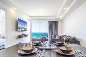a dining room with a table with a view of the ocean at Panoramic beach front condo Verano 1703 in Puerto Peñasco +21 photos