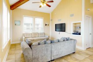 Una sala de estar con un sofá y un televisor de pantalla plana. en Amazing Gulf Views Steps to Beach Family Fun, en Crystal Beach