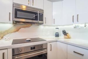 a kitchen with white cabinets and a microwave at Panoramic beach front condo Verano 1703 in Puerto Peñasco