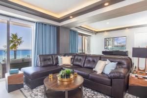 ein Wohnzimmer mit einer Ledercouch und einem Tisch in der Unterkunft Stunning 1 bedroom condominium (Encantame Verano 203) in Playa Encanto