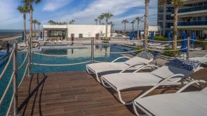 ein Resort mit einem Pool mit Stühlen und Palmen in der Unterkunft Stunning 1 bedroom condominium (Encantame Verano 203) in Playa Encanto