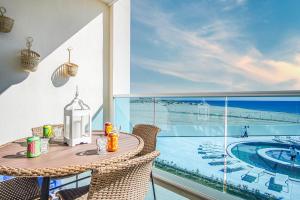 ein Tisch und Stühle auf einem Balkon mit Blick auf das Meer in der Unterkunft Stunning 1 bedroom condominium (Encantame Verano 203) in Playa Encanto