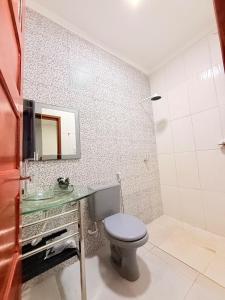 a bathroom with a toilet and a sink at Nina lar in Boa Vista +5 photos