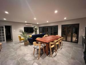 a living room with a wooden table and chairs at 18 On Louvre Guesthouse in Paarl