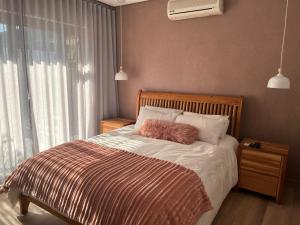 a bedroom with a bed with a brown and white blanket at 18 On Louvre Guesthouse in Paarl +13 photos