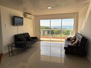 - un salon avec deux chaises et une télévision à écran plat dans l'établissement Club House, à Maizal