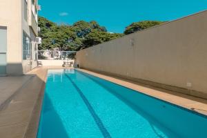 a swimming pool with blue water next to a building at Aproveite este achado! - GC1108 in Maringá