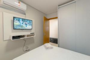 a bedroom with a bed and a tv on the wall at Aproveite este achado! - GC1108 in Maringá