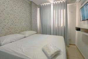 a white bed in a room with a window at Aproveite este achado! - GC1108 in Maringá