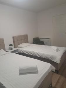 um quarto com duas camas e uma cadeira em SarajevoCityView1 em Saraievo