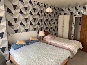a bedroom with two beds and a geometric wall at Bramleigh Hotel in Blackpool