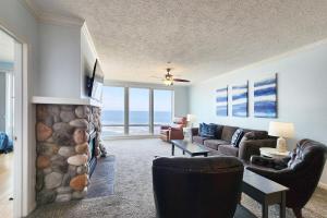 a living room with a fireplace with a view of the ocean at Spectacular Ocean Front Condo with Community Club House & Pool! Whale Crossing in Depoe Bay