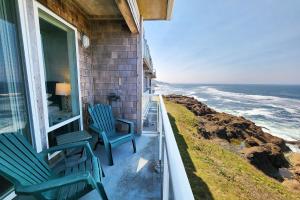 two chairs sitting on a porch looking at the ocean at Spectacular Ocean Front Condo with Community Club House & Pool! Whale Crossing in Depoe Bay