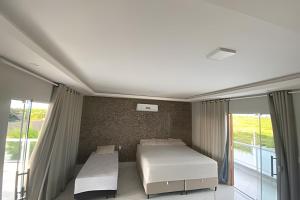 a bedroom with a white bed and a window at Eficiência - Casa Recanto dos Ventos in Camocim +14 photos