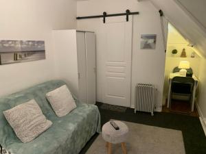 a living room with a green couch and a stool at 45 Grande Rue bis in Ault