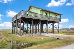 a house on a wooden structure with a porch at Escape Bay Views Large Deck Group Ready in Port Bolivar