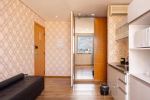 a living room with a couch and a kitchen at Hospedez - Flat Osasco Trade Center in Osasco +164 photos