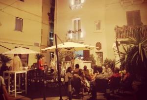 un grupo de personas sentadas en sillas bajo sombrillas en B&B San Francesco, en Taranto