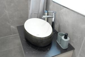 a bathroom with a white sink on a black counter at Wohnung IA - Elegante Mini-Suite in Neuwied