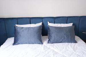 a blue headboard with two blue pillows on a bed at Luxury Apartments - Wohnung IA - Elegante Mini-Suite I Stock in Neuwied