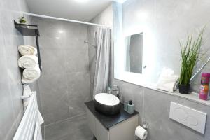 a bathroom with a sink and a shower with a toilet at Luxury Apartments - Wohnung IA - Elegante Mini-Suite I Stock in Neuwied