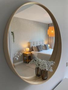 ein Spiegel in einem Schlafzimmer mit einem Bett und Blumen in der Unterkunft Ipanema spa resort, large terrace, golf, 10min to beach, mountain views in Mijas Costa